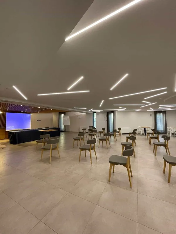 Sala meeting con sedie disposte a platea e schermo per proiezioni