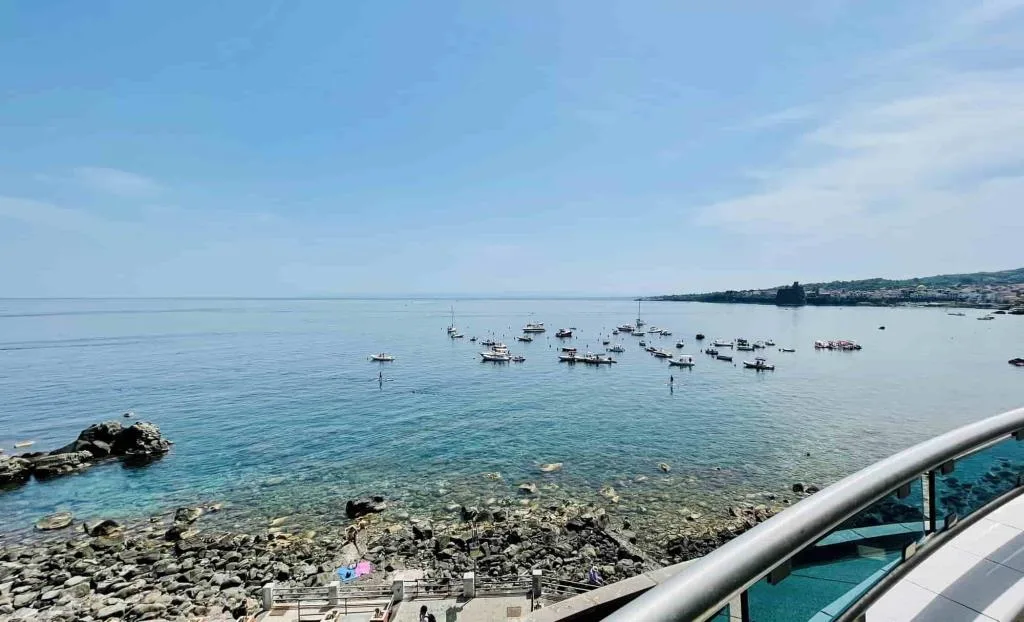 Vista panoramica sul mare con barche e costa dalla terrazza