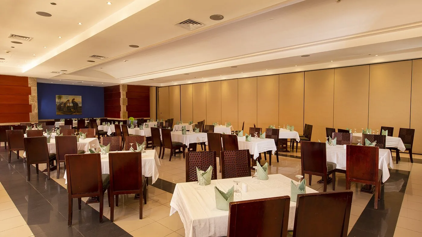 Sala ristorante elegante con tavoli apparecchiati di bianco e sedie in legno scuro
