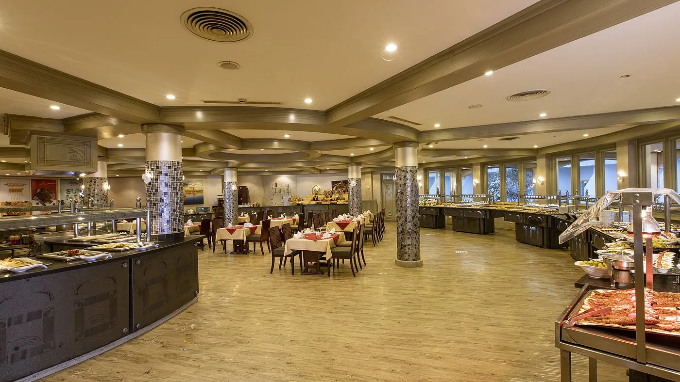 Ampia sala ristorante a buffet con tavoli apparecchiati e colonne decorate