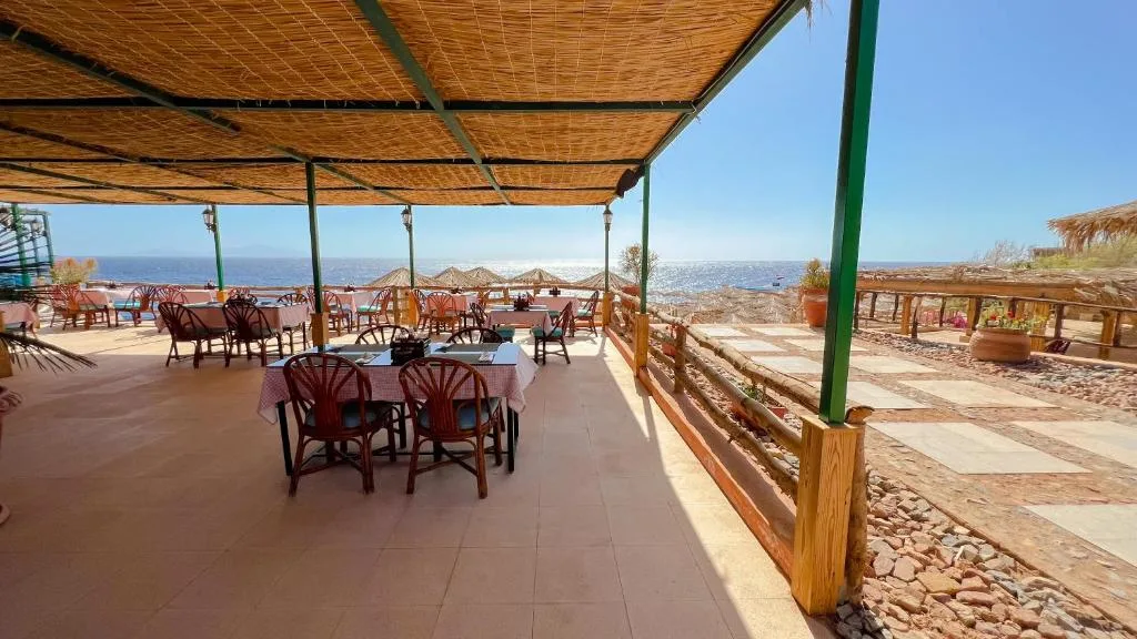 Ristorante coperto all'aperto con tavoli e sedie affacciato sul mare
